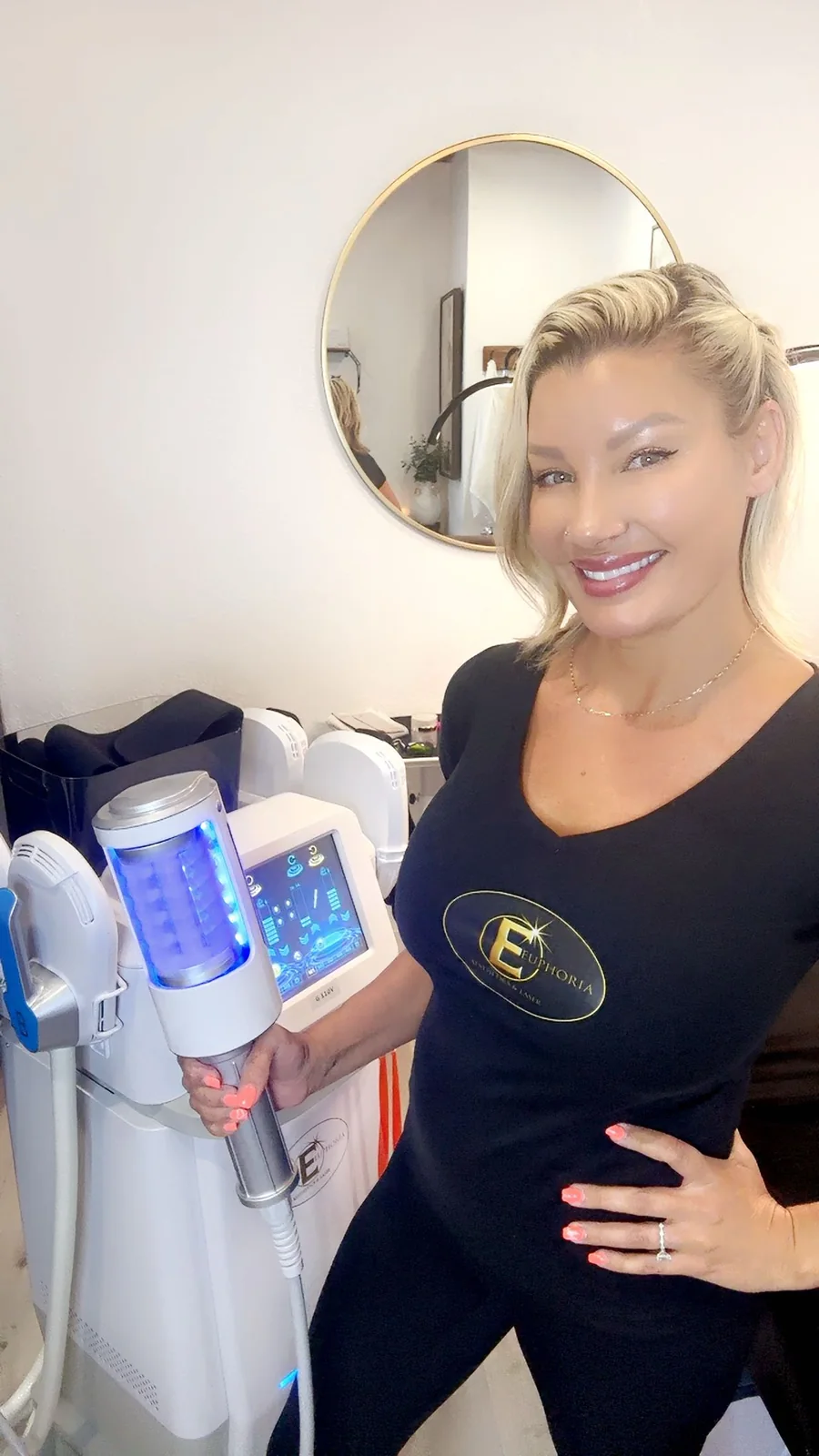 Euphoria provider holding a body-contouring applicator beside treatment equipment.